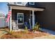 The cozy front porch has rocking chairs, an American flag, and decorative landscaping for a welcoming feel at 446 Brannon Meadows Dr, York, SC 29745