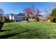 Large backyard featuring green grass, a fire pit, a shed, and a wooded fence at 4717 Doris Ave, Charlotte, NC 28205