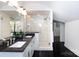 Light-filled bathroom featuring double sinks, granite countertops, a glass shower and dark hardwood flooring at 4717 Doris Ave, Charlotte, NC 28205