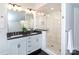 Bright bathroom featuring a double sink vanity, granite countertops, and a tiled glass shower at 4717 Doris Ave, Charlotte, NC 28205