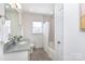 Bright bathroom featuring a tub with shower, subway tile, grey floors and a grey countertop at 4717 Doris Ave, Charlotte, NC 28205