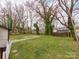 Spacious backyard with mature trees and landscaping and sidewalk at 507 N Oakland St, Gastonia, NC 28052