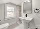 Modern bathroom featuring white tiles, black fixtures and a stylish pedestal sink at 507 N Oakland St, Gastonia, NC 28052