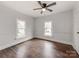 Charming bedroom with white paneled walls, hardwood floors, and a ceiling fan at 507 N Oakland St, Gastonia, NC 28052