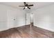 Well-lit bedroom featuring wood paneling, hardwood floors, and a ceiling fan at 507 N Oakland St, Gastonia, NC 28052