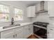 Charming kitchen features stainless steel appliances, bright white cabinets, and hardwood floors at 507 N Oakland St, Gastonia, NC 28052