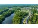 Expansive aerial view showcasing a community nestled between a river and lush woodland at 5136 Samoa Ridge Dr, Lancaster, SC 29720