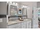 Bright bathroom featuring dual sinks with granite countertops, framed mirrors, and elegant lighting fixtures at 5136 Samoa Ridge Dr, Lancaster, SC 29720