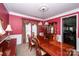 Elegant dining room with rich red walls, a chandelier, and a polished wood table with seating for six at 625 Circle Trace Rd, Monroe, NC 28110