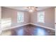 A cozy bedroom featuring hardwood floors, a ceiling fan, and dual windows providing natural light at 6282 Richburg Rd, Great Falls, SC 29055