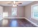 Bright bedroom with hardwood floors, a ceiling fan, and two windows that flood the room with natural light at 6282 Richburg Rd, Great Falls, SC 29055