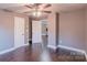 Bedroom with hardwood floors, ceiling fan, and view to kitchen and entry doors at 6282 Richburg Rd, Great Falls, SC 29055