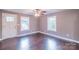 Living room featuring a ceiling fan, two windows, and gleaming wood floors at 6282 Richburg Rd, Great Falls, SC 29055