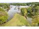 Aerial view showcasing the waterfront property with mature trees, well-maintained lawn, and boat dock access at 7790 Blackwood Rd, Denver, NC 28037