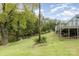 Backyard of the home with a wooden deck, mature trees and vegetation with the view of the pond at 7790 Blackwood Rd, Denver, NC 28037