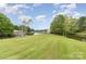 View of backyard and the waterfront featuring calm water and lush trees under a partly cloudy blue sky at 7790 Blackwood Rd, Denver, NC 28037