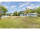 Exterior view of a manufactured home with a large yard and view of the lake on a sunny day at 7790 Blackwood Rd, Denver, NC 28037