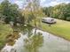 Picturesque pond view with a dock, mature trees, and a cozy home in a serene setting at 7790 Blackwood Rd, Denver, NC 28037