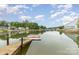 Scenic waterfront view featuring a private dock, calm water, and lush green trees under a partly cloudy blue sky at 7790 Blackwood Rd, Denver, NC 28037