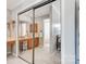 Bathroom with large mirrored closet doors, vanity with wood cabinets, and view into the walk-in shower at 8250 Tradd Ct, Charlotte, NC 28210