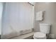 Bathroom showcasing a toilet, towel rack with towel, and a shower with a closed white shower curtain at 8250 Tradd Ct, Charlotte, NC 28210