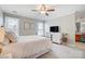 Bright bedroom with a ceiling fan, neutral walls, white dresser and a view into the en-suite bathroom at 8250 Tradd Ct, Charlotte, NC 28210