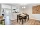 Dining room adjacent to kitchen featuring modern chandelier and hardwood floors at 8250 Tradd Ct, Charlotte, NC 28210