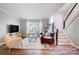 Cozy living room featuring hardwood floors, staircase, and plenty of natural light at 8250 Tradd Ct, Charlotte, NC 28210