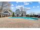 Outdoor community pool house with a pool, brick pathway, black metal fence and green landscaping at 8250 Tradd Ct, Charlotte, NC 28210