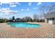 Community pool surrounded by brick with clear blue water and a bath house next to it at 8250 Tradd Ct, Charlotte, NC 28210