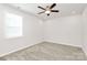 Comfortable bedroom with soft carpeting, ceiling fan, and a bright window at 9650 Liberty Hill Dr, Mint Hill, NC 28227