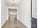 Inviting foyer with wood flooring, white wainscoting, and a view into the open-concept living area at 9650 Liberty Hill Dr, Mint Hill, NC 28227