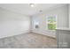 A spare bedroom with light gray walls, carpet, two large windows, and a dresser at 117 Cramerton Mills Pkwy, Cramerton, NC 28032