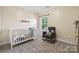 A Bedroom with a crib, glider, and natural light from the window at 117 Cramerton Mills Pkwy, Cramerton, NC 28032