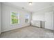 A spare bedroom with light gray walls, carpet, two large windows, and a dresser at 117 Cramerton Mills Pkwy, Cramerton, NC 28032