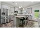 Well-lit kitchen featuring stainless steel appliances, a granite island, and hardwood floors at 117 Cramerton Mills Pkwy, Cramerton, NC 28032