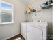 A bright laundry room with washer, dryer, shelving and a window at 117 Cramerton Mills Pkwy, Cramerton, NC 28032