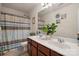 Bathroom featuring a double sink vanity with cabinets, shower with curtains, and green plants at 12502 Bending Branch Rd, Charlotte, NC 28227