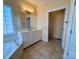 Bright bathroom featuring tile floors, a soaking tub, and a white vanity with ample cabinet space at 1419 Ridge St, Albemarle, NC 28001