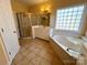 Spacious bathroom featuring a soaking tub, separate shower, and tiled floors for a clean and modern feel at 1419 Ridge St, Albemarle, NC 28001