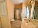 A charming bathroom with tile flooring, vanity, and a shower with patterned curtain at 1419 Ridge St, Albemarle, NC 28001