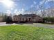 Charming brick home boasts a lush green lawn, mature trees, and a welcoming circular driveway at 1419 Ridge St, Albemarle, NC 28001