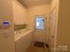 Functional laundry room with washer, dryer, and overhead cabinets, offering convenience and storage at 1419 Ridge St, Albemarle, NC 28001