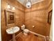 Charming powder room with decorative wallpaper, pedestal sink, and ornate mirror at 1419 Ridge St, Albemarle, NC 28001