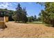 View of the backyard featuring an enclosed tennis court with lush greenery and mature trees at 143 Lakewind Dr, Mooresville, NC 28115