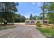 Home with gravel driveway surrounded by mature trees and nature on a spacious lot at 143 Lakewind Dr, Mooresville, NC 28115