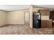 Living room and kitchen area with wood floor and black refrigerator at 143 Lakewind Dr, Mooresville, NC 28115