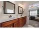 Bathroom with double sink, dark wood vanity and mirrors, with view into the main bedroom at 1736 Townsend Ln, Rock Hill, SC 29730