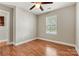 This is a clean bedroom with vinyl floors, a ceiling fan, and a large window at 301 N 4Th Ave, Maiden, NC 28650