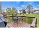 Outdoor deck with a grill and dining table, perfect for entertaining and enjoying the serene backyard views at 301 N 4Th Ave, Maiden, NC 28650